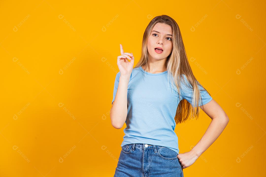 Mulher jovem pensativa em roupas casuais posando isolado no retrato de estúdio de fundo de parede amarela