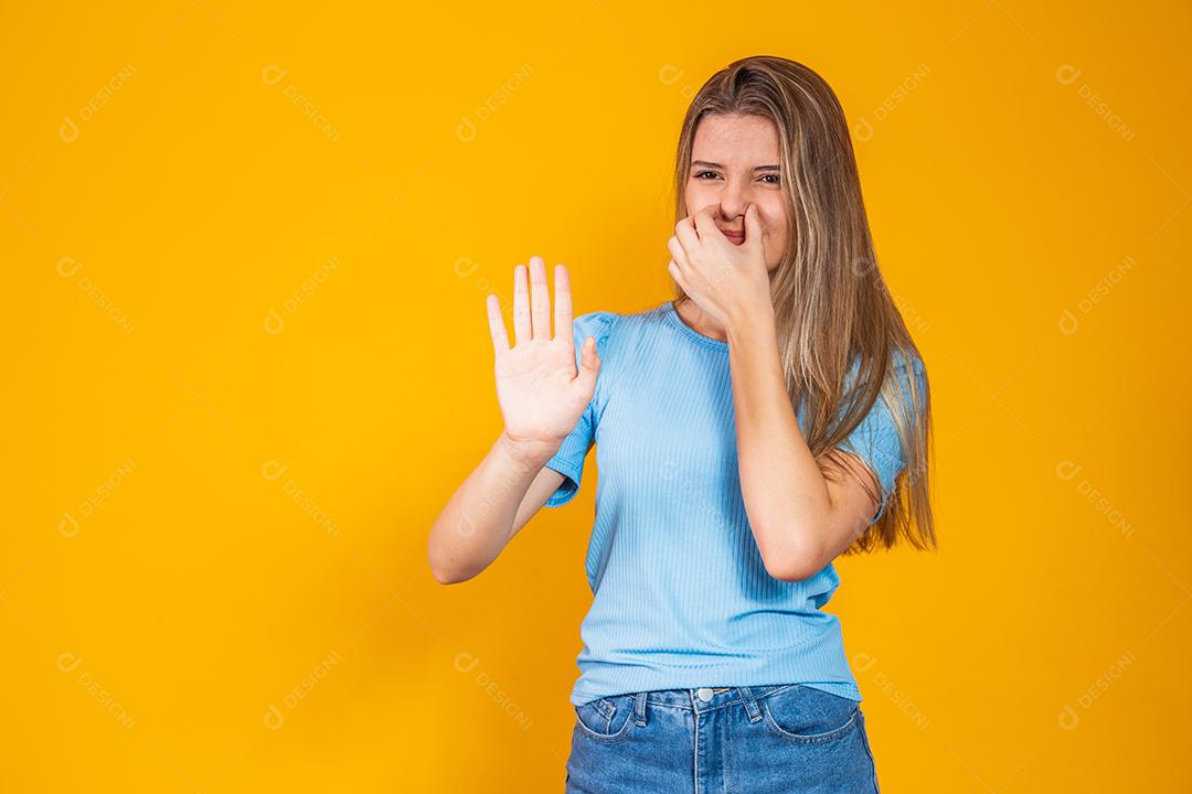 mulher cobrindo o nariz por mau cheiro, conceito de coisa fedorenta, mau hálito, cheiro desagradável