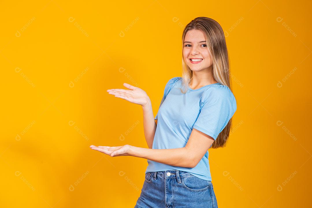 Jovem caucasiana apontando para o lado com espaço livre para texto e boca aberta.