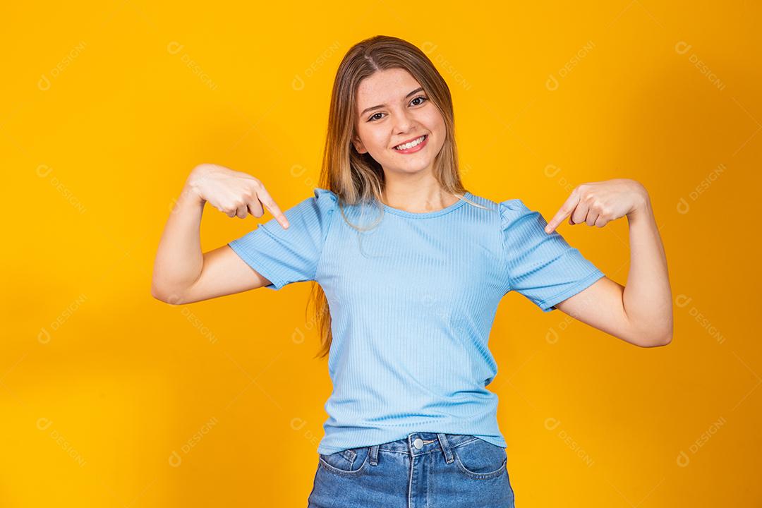 Jovem mulher caucasiana natural aponta para baixo com os dedos, sentimento positivo.