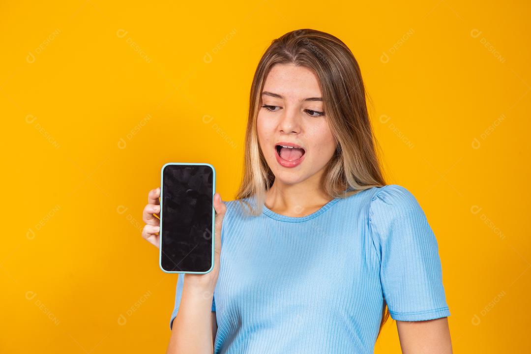 Jovem loira mostrando a tela do celular