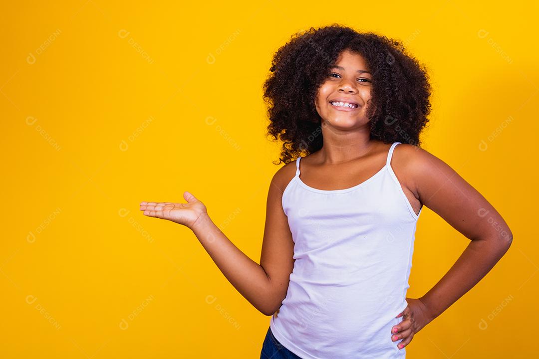 linda criança afro apontando para o lado