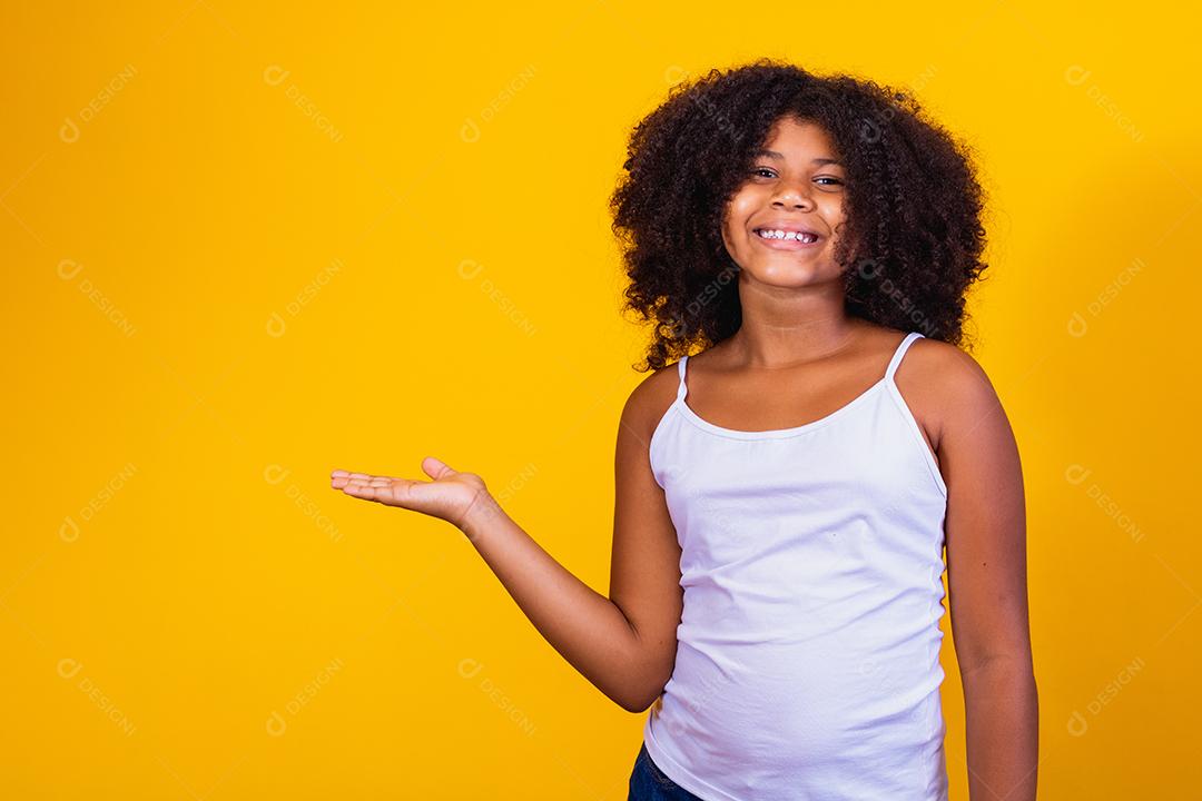linda criança afro apontando para o lado com espaço para texto