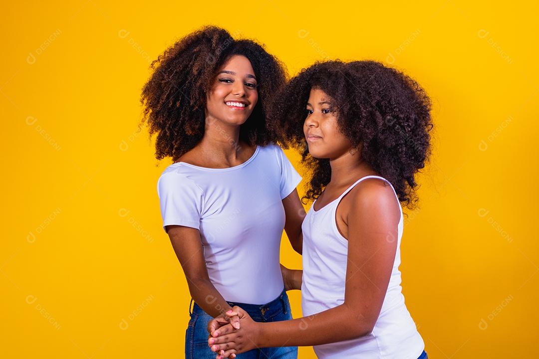 afro mãe e filha dançando em fundo amarelo