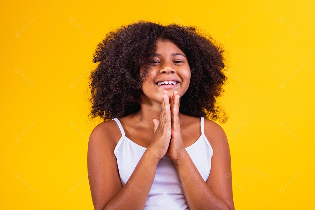 Linda criança afro-americana com as mãos juntas em gesto de oração expressando esperança e por favor conceito