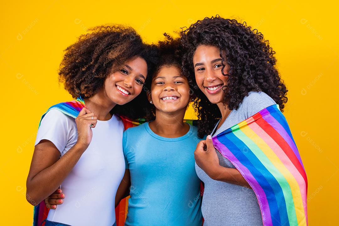 Feliz casal de lésbicas com criança em fundo amarelo. Casal junto com filha adotiva, conceito de adoção