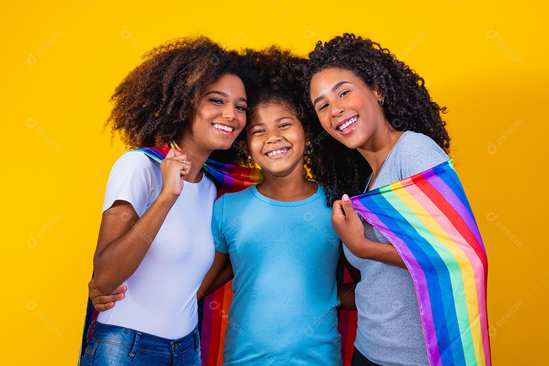 Feliz casal de lésbicas com criança em fundo amarelo. Casal junto com filha adotiva, conceito de adoção