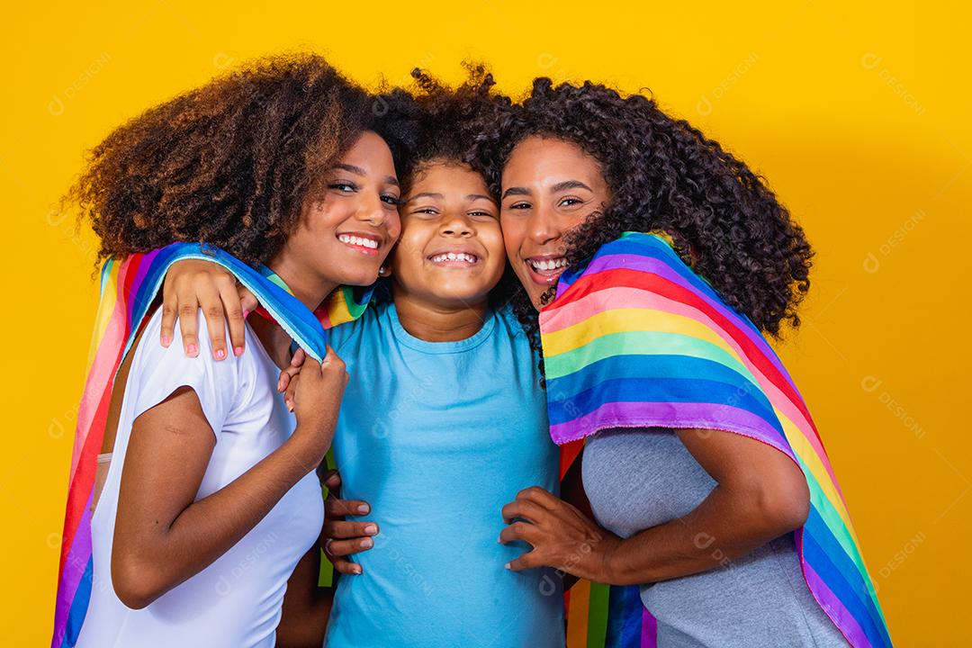 Feliz casal de lésbicas com criança em fundo amarelo. Casal junto com filha adotiva, conceito de adoção