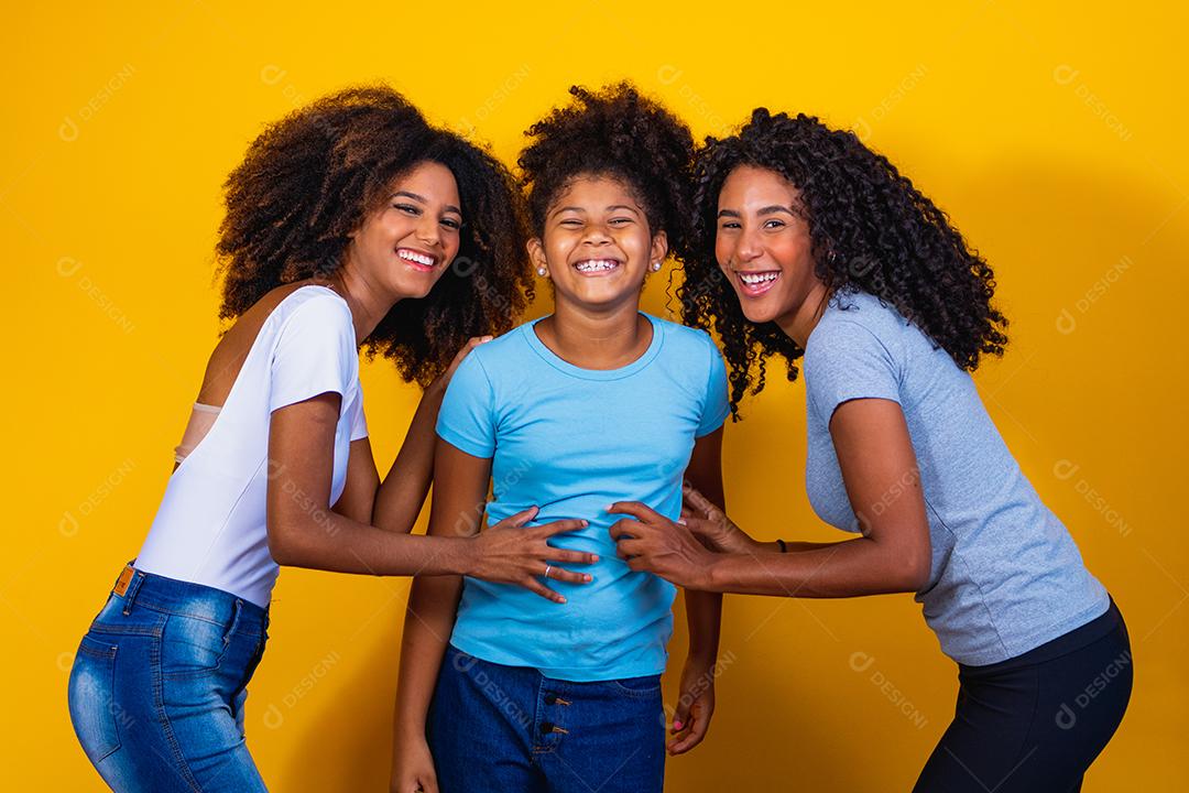 Feliz casal de lésbicas com criança em fundo amarelo. Casal junto com filha adotiva, conceito de adoção