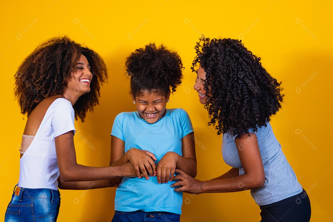 Feliz casal de lésbicas com criança em fundo amarelo. Casal junto com filha adotiva, conceito de adoção