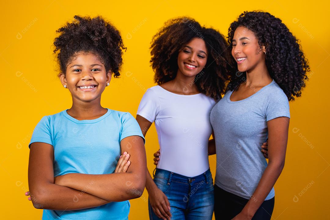 Feliz casal de lésbicas com criança em fundo amarelo. Casal junto com filha adotiva, conceito de adoção