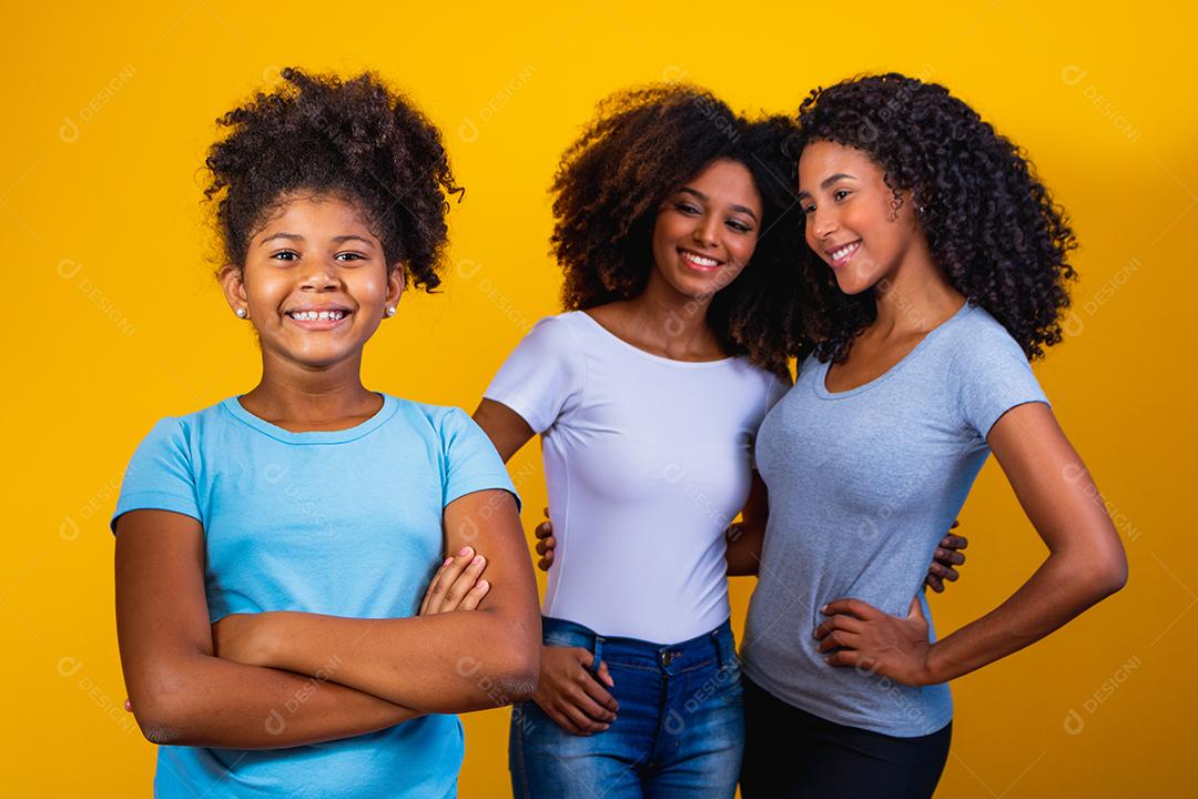Feliz casal de lésbicas com criança em fundo amarelo. Casal junto com filha adotiva, conceito de adoção