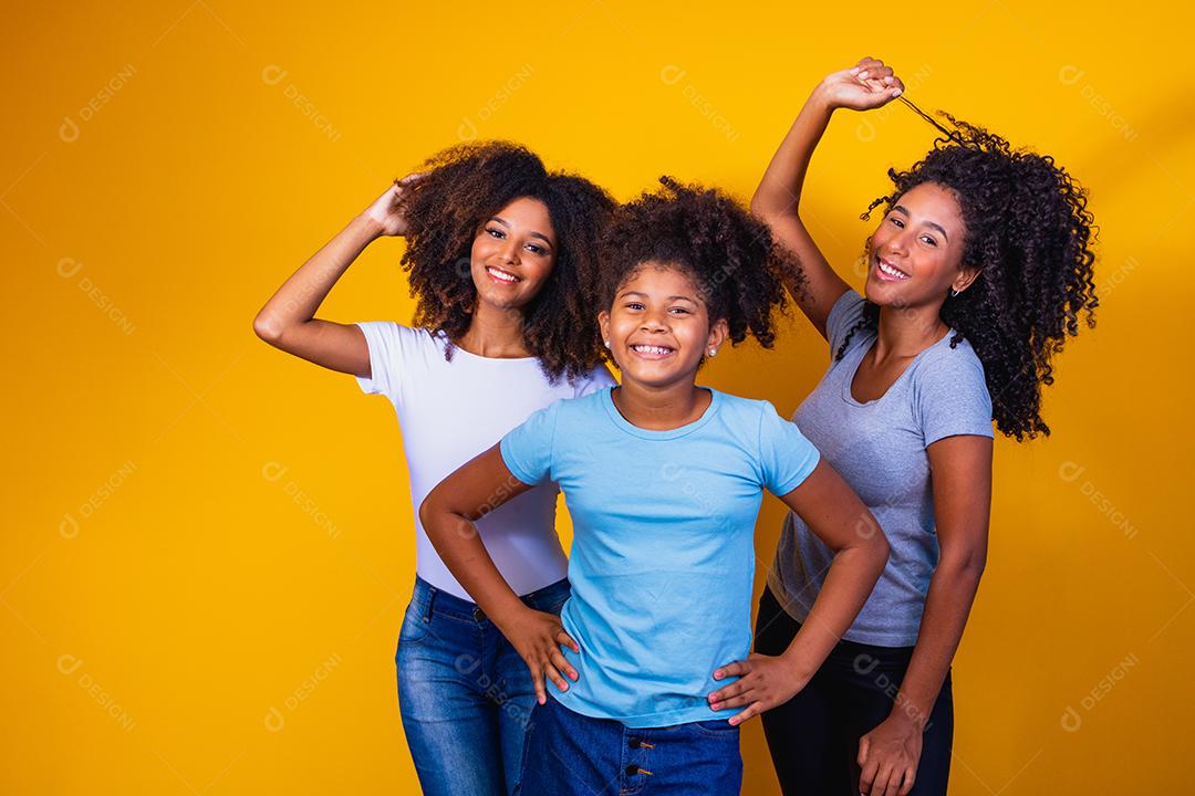 Feliz casal de lésbicas com criança em fundo amarelo. Casal junto com filha adotiva, conceito de adoção