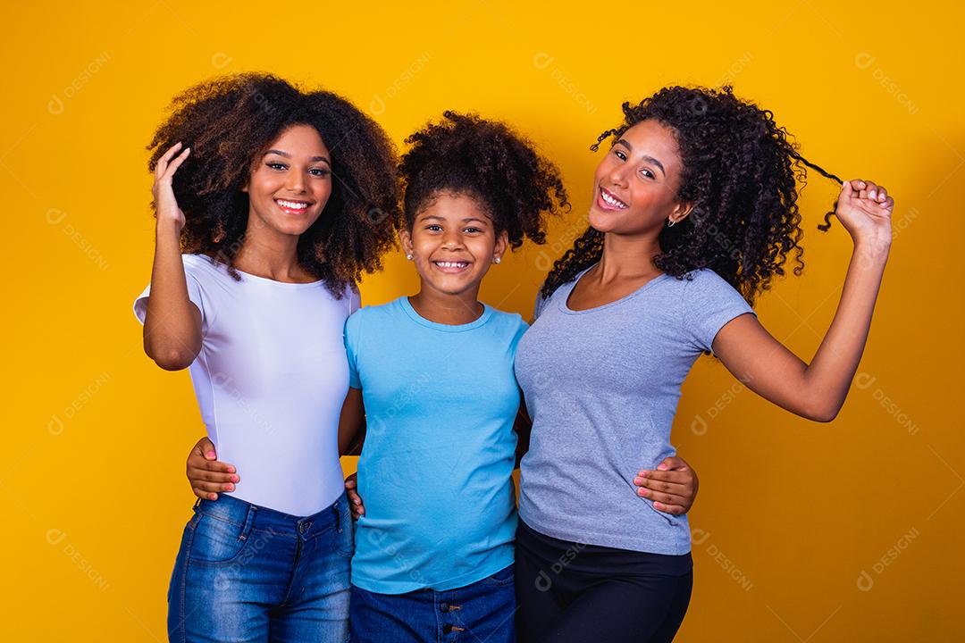 Feliz casal de lésbicas com criança em fundo amarelo. Casal junto com filha adotiva, conceito de adoção