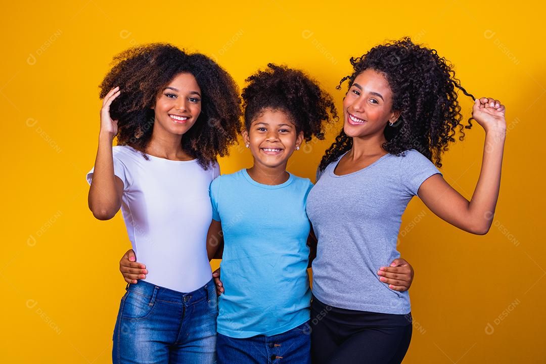 Feliz casal de lésbicas com criança em fundo amarelo. Casal junto com filha adotiva, conceito de adoção