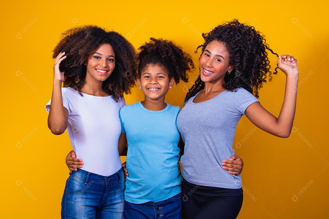 Feliz casal de lésbicas com criança em fundo amarelo. Casal junto com filha adotiva, conceito de adoção