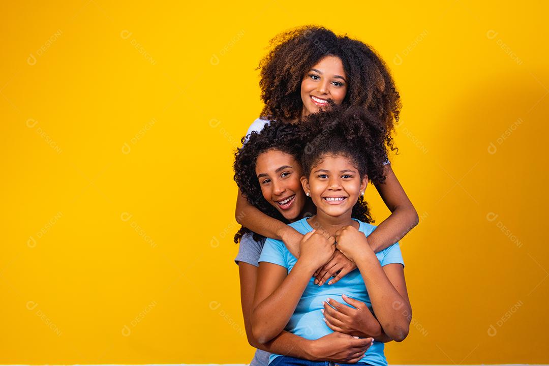 Feliz casal de lésbicas com criança em fundo amarelo. Casal junto com filha adotiva, conceito de adoção