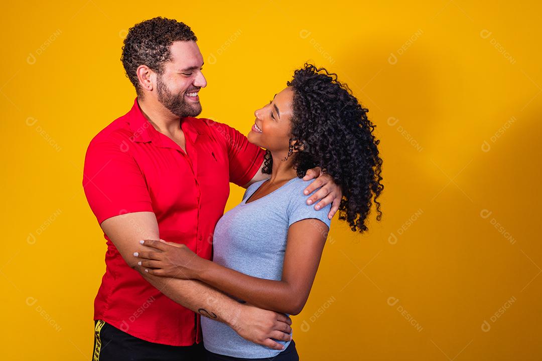 Retrato de namorados de casal de conteúdo em roupas básicas sorrindo para a câmera
