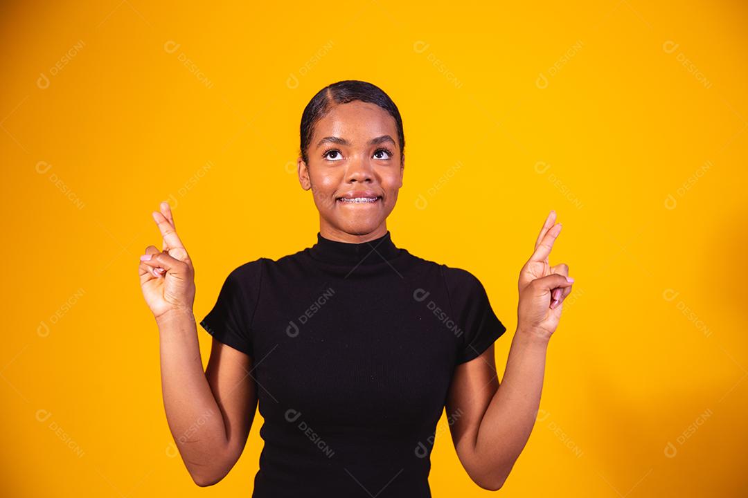 Conceito de fofoca. Curiosa jovem afro segurando a mão perto da orelha, tentando ouvir informações interessantes