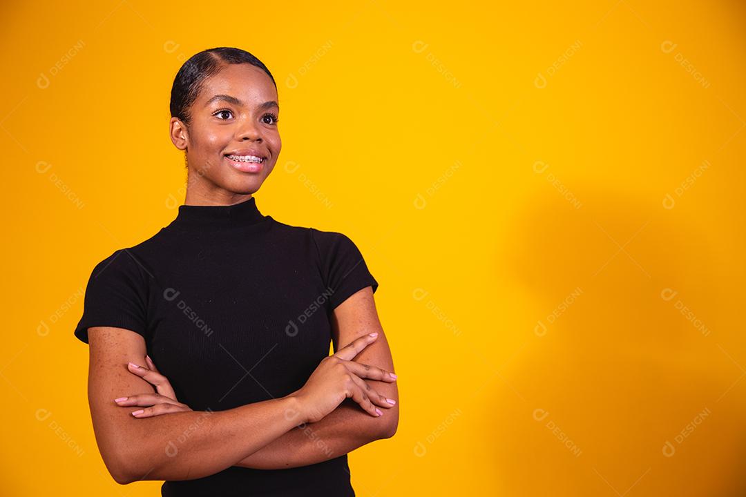 mulher negra em fundo amarelo com os braços cruzados. mulher de negócios em fundo amarelo
