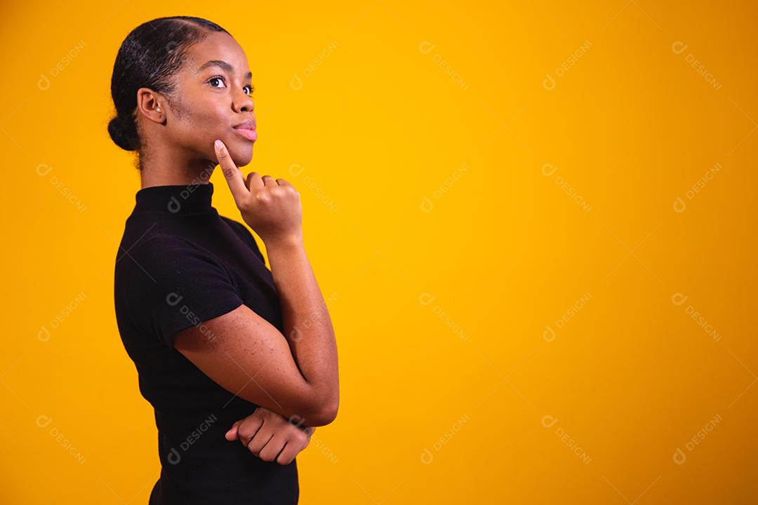 mulher pensando em fundo amarelo. Mulher confusa e pensativa
