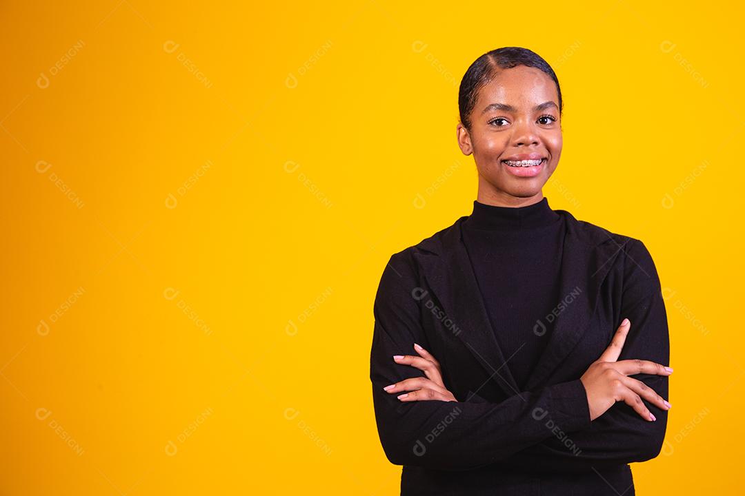 mulher negra em fundo amarelo com os braços cruzados. mulher de negócios em fundo amarelo