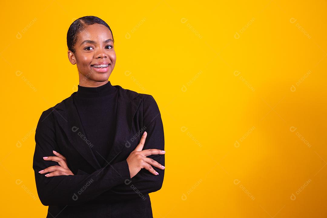 mulher negra em fundo amarelo com os braços cruzados. mulher de negócios em fundo amarelo