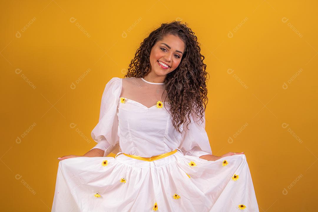 jovem afro vestida para festa junina sorrindo para a câmera
