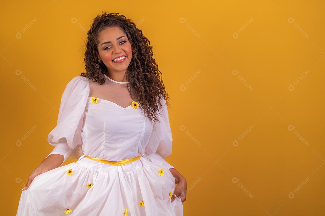 jovem afro vestida para festa junina sorrindo para a câmera