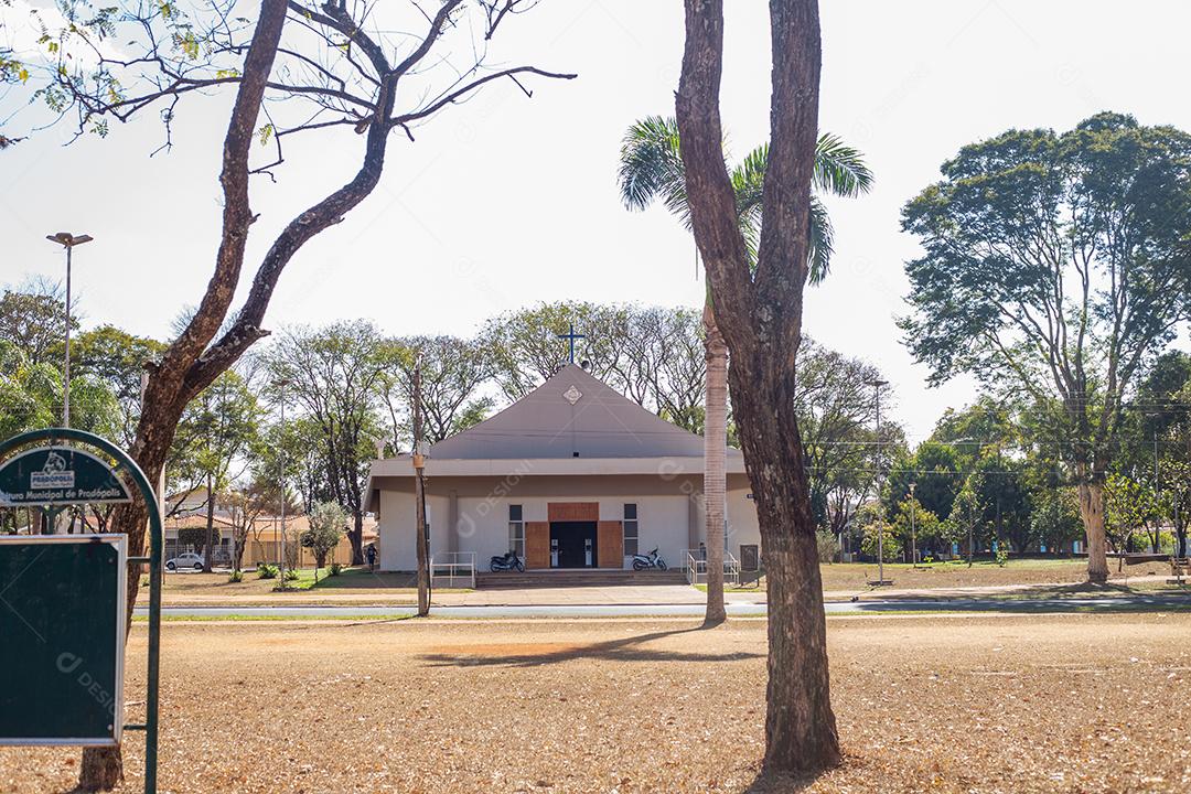 Paisagem de seca com igreja branca e arvores com folhas verdes