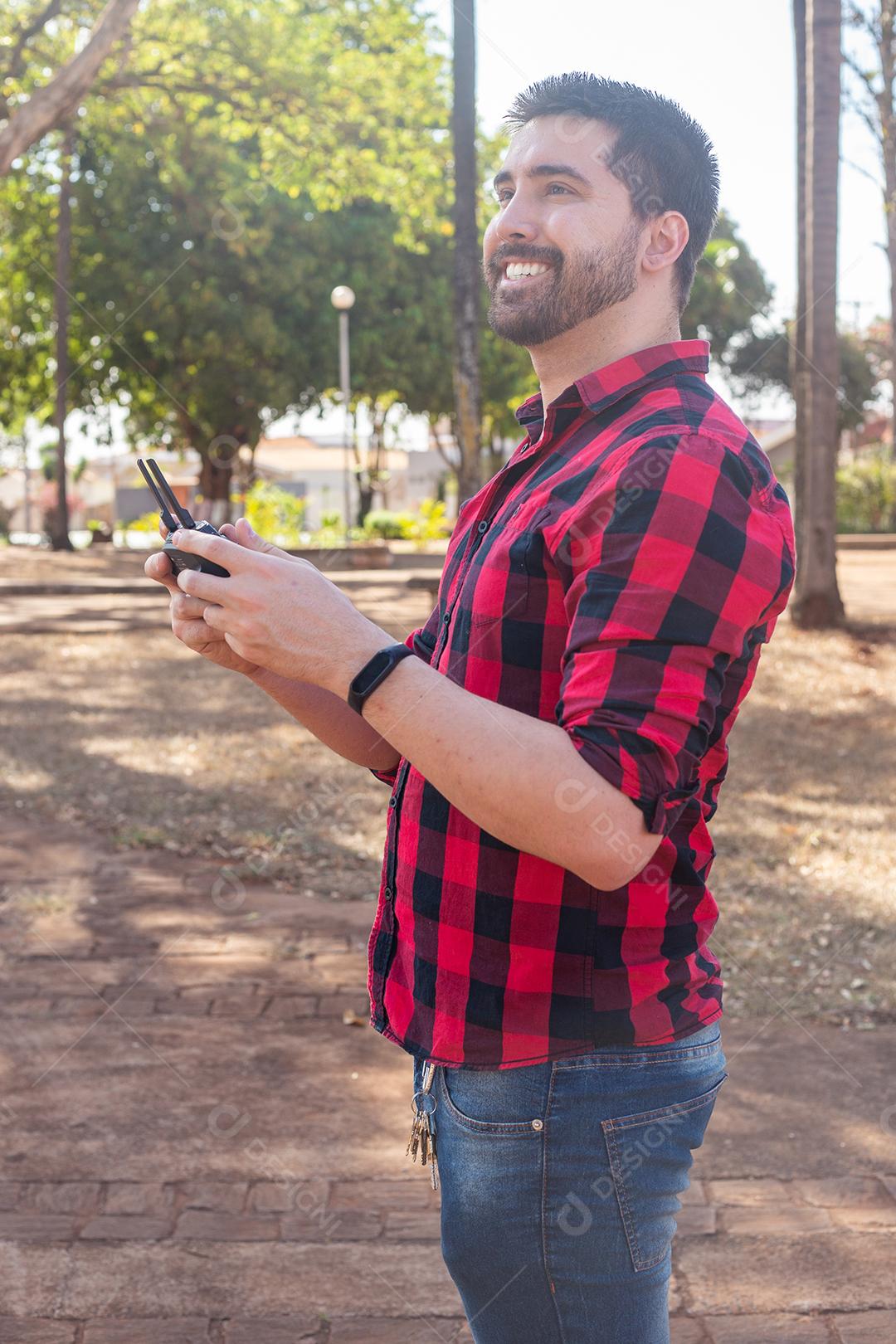 Homem com camisa xadrez segurando controle de drone imagem JPG