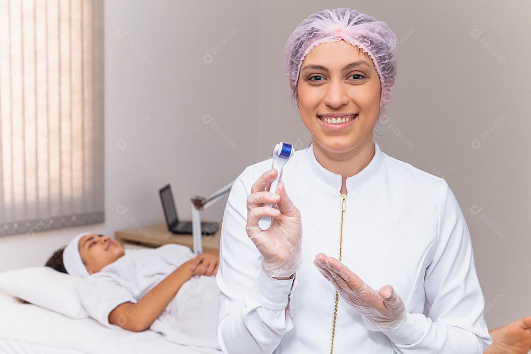 closeup na esteticista segurando microagulhamento sorrindo para uma câmera