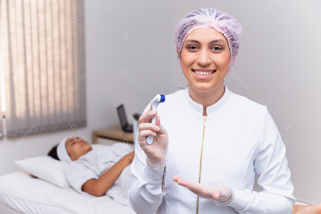 closeup na esteticista segurando microagulhamento sorrindo para uma câmera