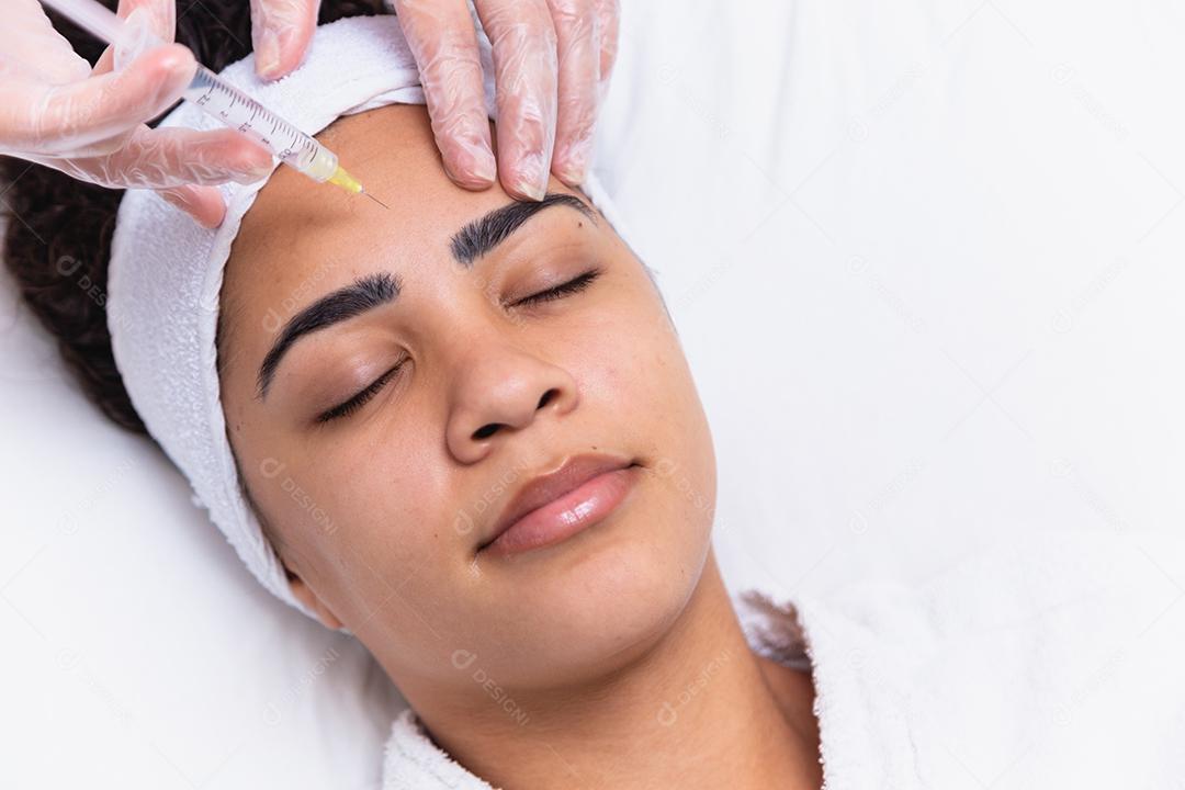 Cirurgia plástica. Jovem mulher africana recebendo injeção de botox