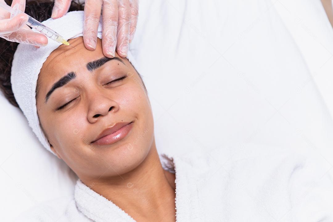 Cirurgia plástica. Jovem mulher africana recebendo injeção de botox