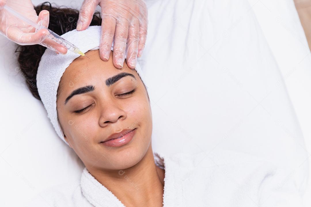 Cirurgia plástica. Jovem mulher africana recebendo injeção de botox