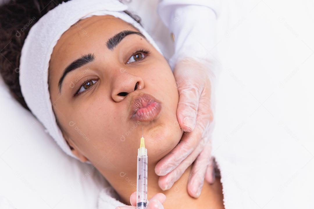 Aumento labial. Boca de mulher jovem e bonita recebendo Hyalur