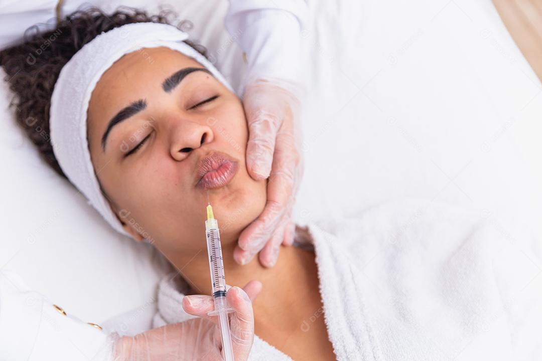 Aumento labial. Boca de mulher jovem e bonita recebendo Hyalur