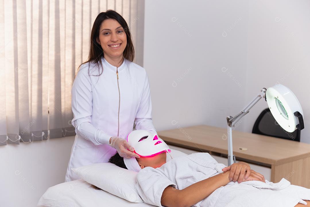 Máscara facial de terapia fotodinâmica no rosto da mulher