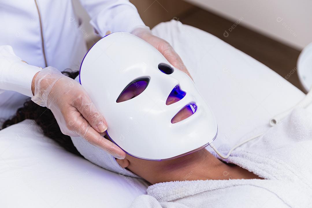 Máscara facial de terapia fotodinâmica no rosto da mulher