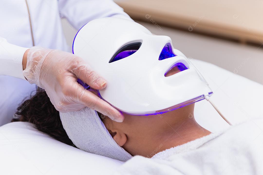 Máscara facial de terapia fotodinâmica no rosto da mulher
