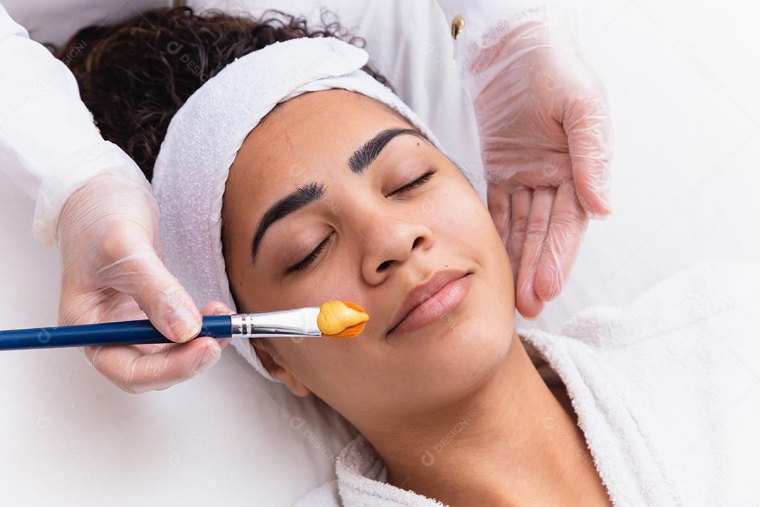 mulher está deitada no consultório do cosmetologista sobre o procedimento de hidratação do rosto