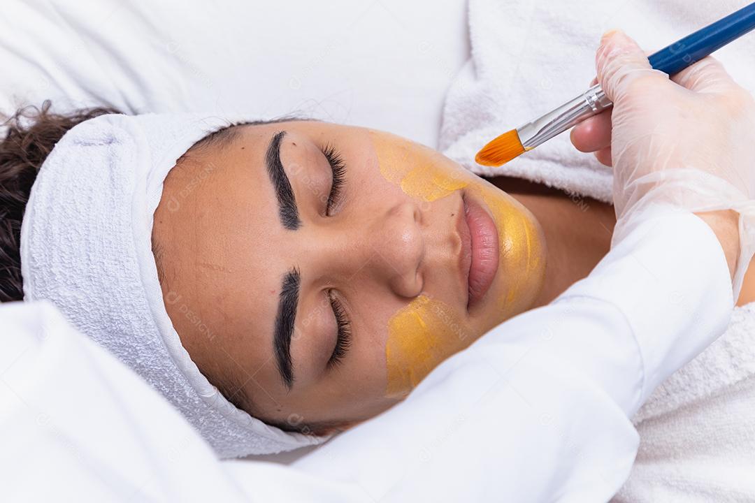 mulher está deitada no consultório do cosmetologista sobre o procedimento de hidratação do rosto