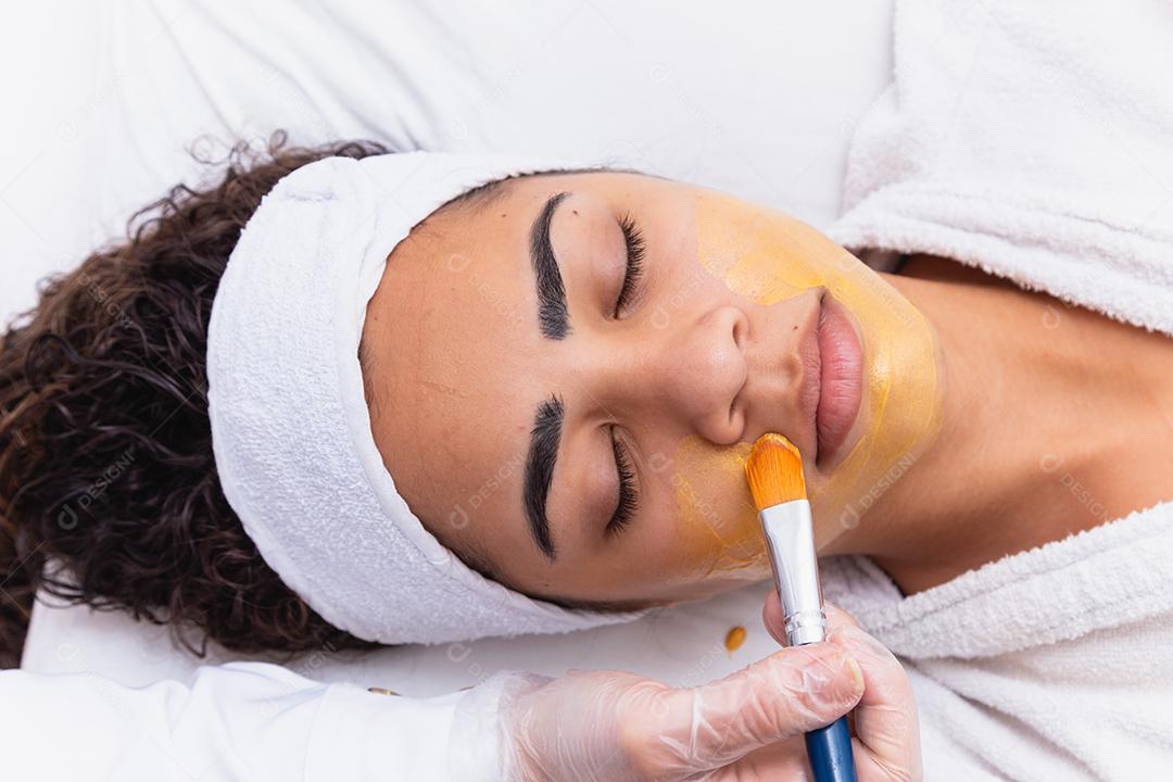 mulher está deitada no consultório do cosmetologista sobre o procedimento de hidratação do rosto