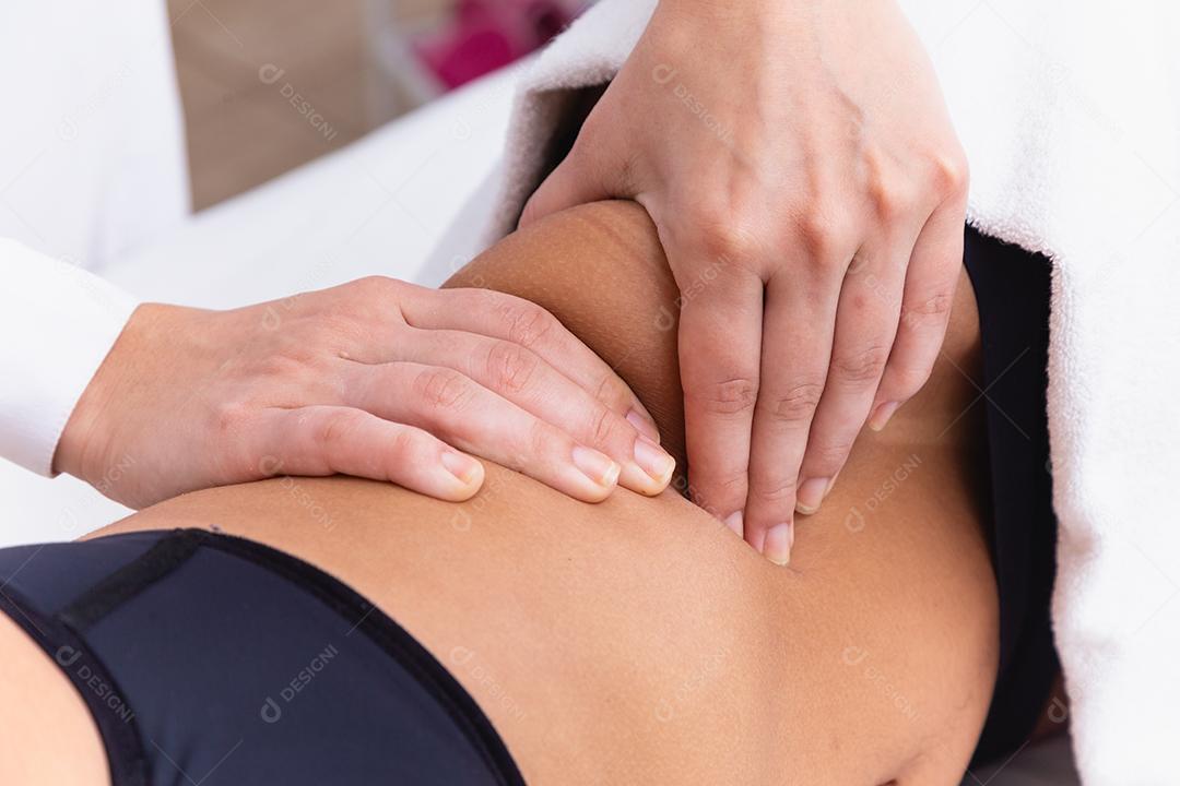 mulher fazendo massagem de modelagem na barriga dela.