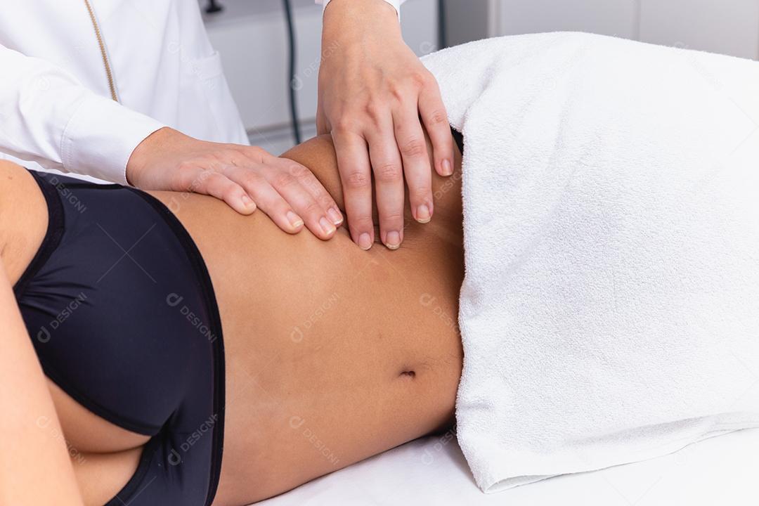 mulher fazendo massagem de modelagem na barriga dela.