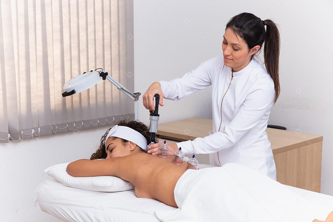 Mulher deitada no peito com tratamento de ventosa nas costas