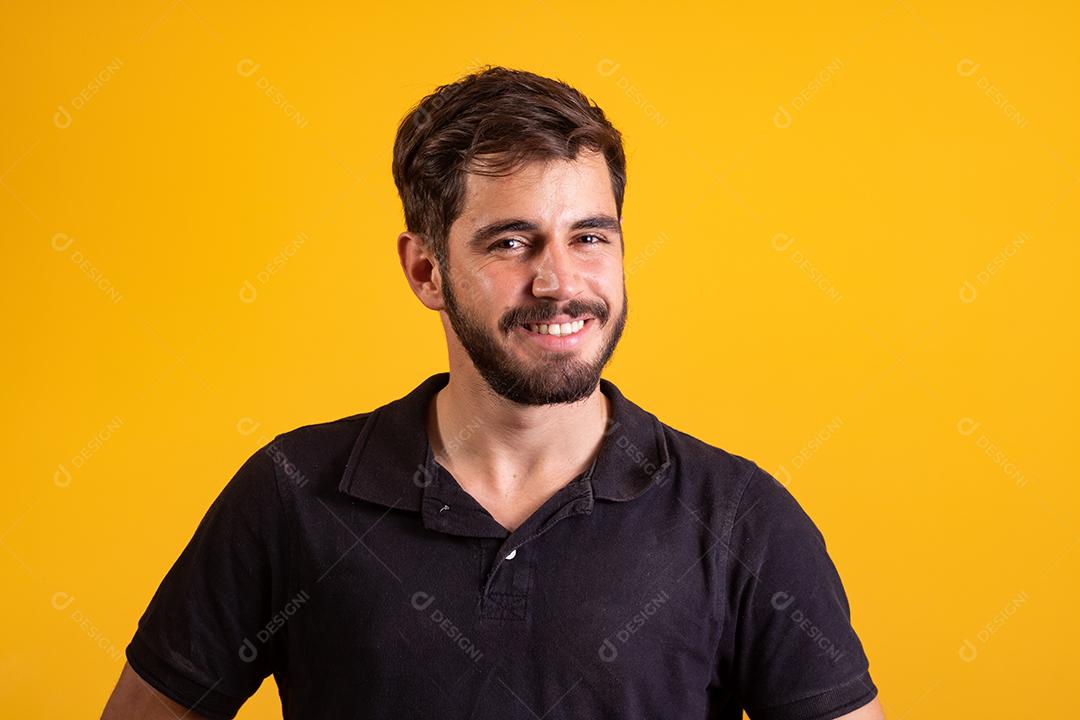 Menino bonito sorrindo olhando para a câmera em fundo amarelo. homem caucasiano sorrindo