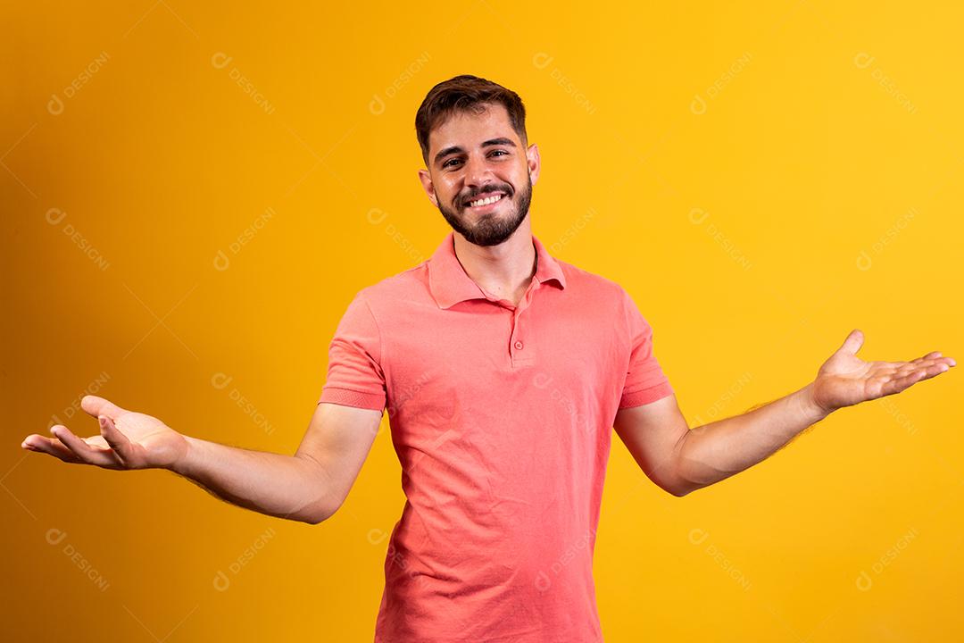 homem bonito sorrindo braços abertos sobre fundo amarelo