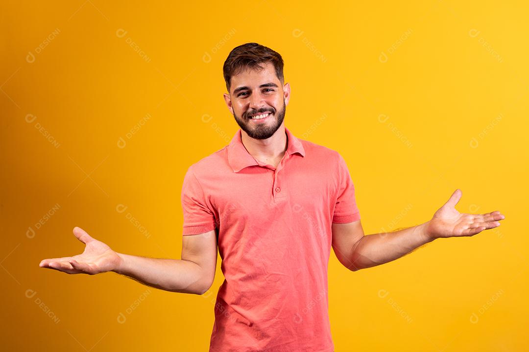 homem bonito sorrindo braços abertos sobre fundo amarelo